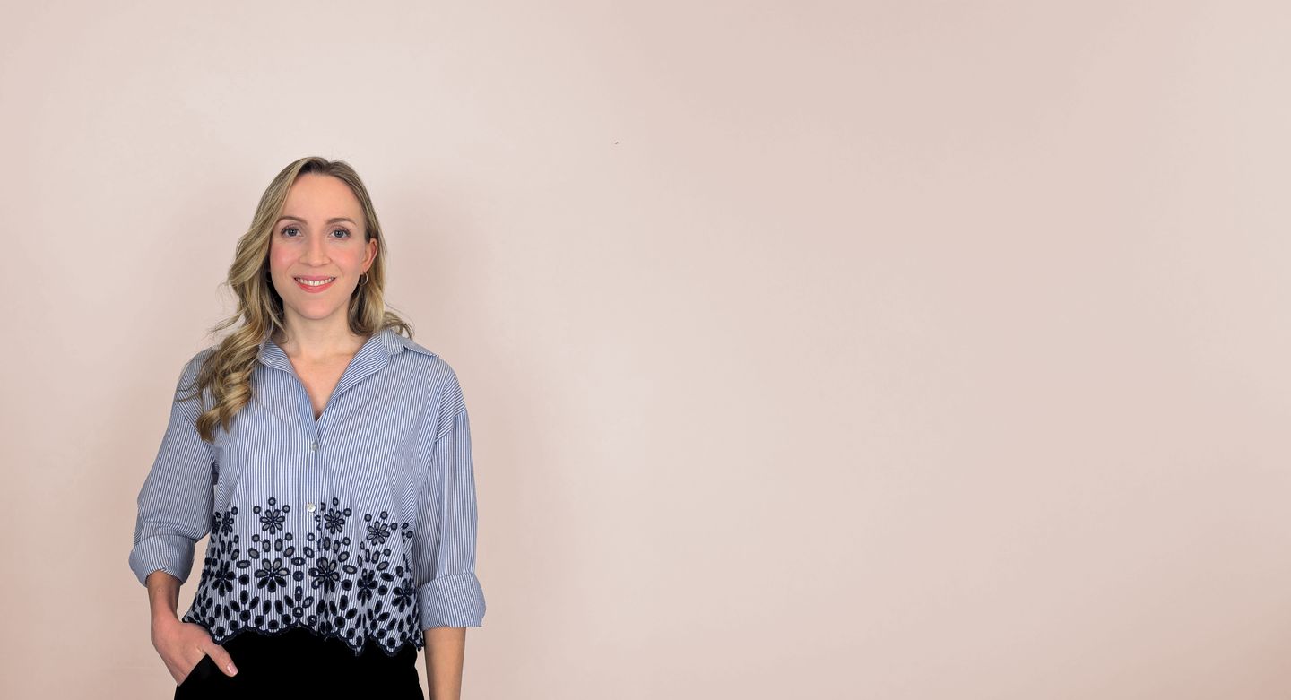 Nina Bonifazi steht lächelnd vor einer rosa Wand